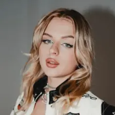 Młoda kobieta z blond włosami, w kurtce w stylu wyścigowym. Wiele osób zastanawia się, ile lat ma Paulina Hornik.
