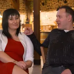 Stefan Koch i Aldona siedzą blisko siebie, rozmawiając w przytulnym wnętrzu.