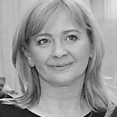 Portret Sylwii Gaj. Uśmiechnięta kobieta o jasnych włosach, uchwycona w czarno-białych kadrach.