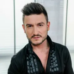 Michał Kwiatkowski, piosenkarz, w wieku około 30 lat, w czarnej koszuli.