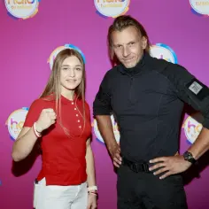 Julia Szeremeta, która pochodzi z Polski, pozuje z mężczyzną na tle różowej ścianki z logo "halo tu polsat".