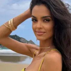 Klaudia El Dursi na plaży, z ręką uniesioną do głowy, w złotych bransoletach. Wiele osób zastanawia się, ile lat ma Klaudia El Dursi.