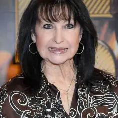 Krystyna Giżowska, uśmiechnięta, w brązowej bluzce z wzorem. Ile lat ma Krystyna Giżowska?