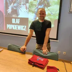 Olaf Popkiewicz, którego wiek jest tajemnicą, prezentuje swoje dokonania. Na ekranie jego imię i nazwisko.