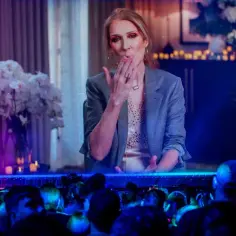 Celine Dion przesyła całusy z ekranu, a publiczność wpatruje się w nią z zachwytem.