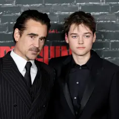 Colin Farrell i jego syn, Barry Keoghan, pozują do zdjęć. Colin ma na sobie prążkowany garnitur, a jego syn czarny smoking.