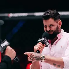 Wojtek Gola, zapytany o swój wiek, uśmiecha się, trzymając mikrofon FAME MMA.