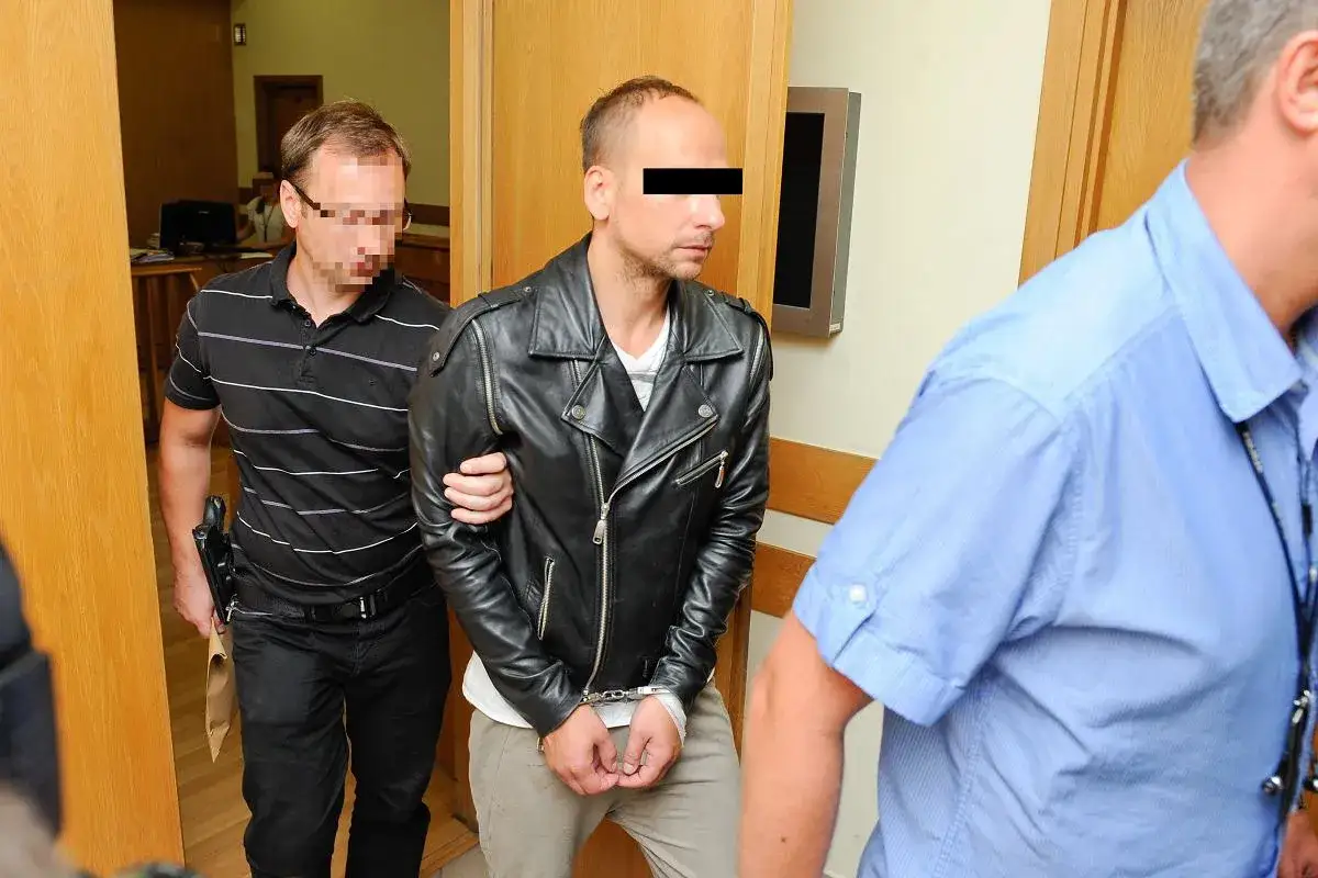 Mężczyzna w skórzanej kurtce, z kajdankami na rękach, prowadzony przez ochroniarzy. Czy to mąż Edyty Górniak nie żyje?