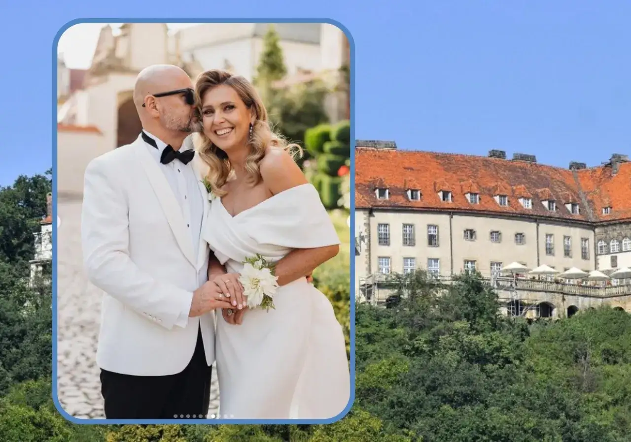 Szczęśliwa para młoda, mąż Ewy Wachowicz w białej marynarce i ona w sukni ślubnej, na tle zamku.