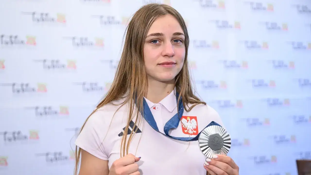Julia Szeremeta, dumna z medalu, prezentuje swoje osiągnięcie. Skąd pochodzi? Z Polski, co symbolizuje orzeł na jej koszulce.